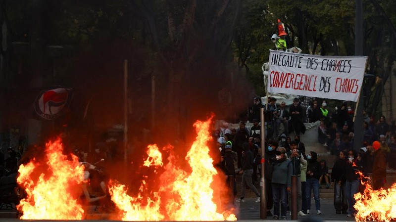 A fire burns next to a sign reading "Inequality of opportunity" during an authorised demonstration organised by a labour union in Marseille, France, October 24, 2026, as part of nationwide protests led by the "Yellow Vests" movement and joined by hig