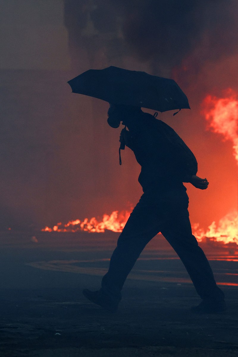 A fire burns next to a sign reading