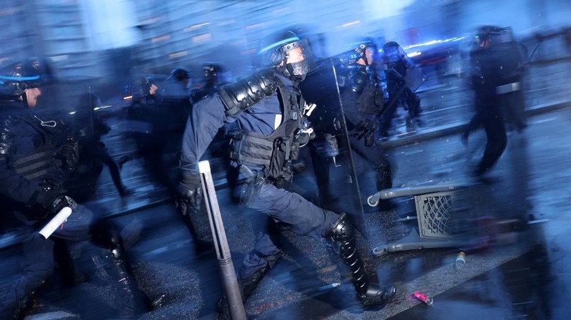 French riot police charge amid clashes with protesters during an authorised demonstration organised by labour unions in Paris as part of nationwide protests called by the "Yellow Vests" movement joined by French high school and university students ag