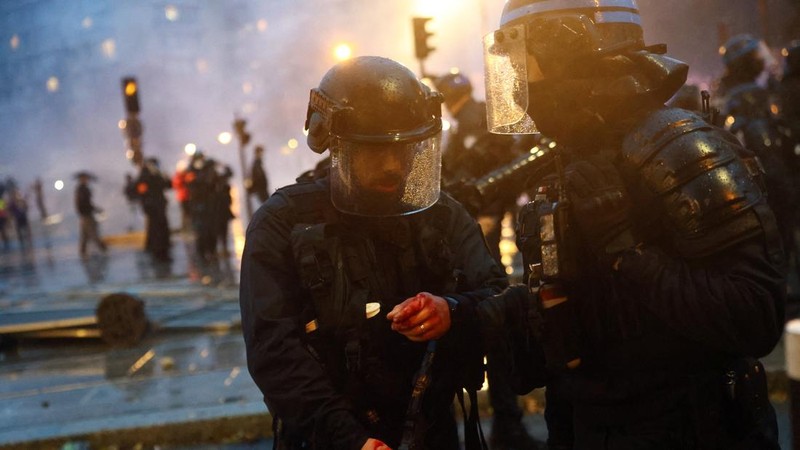 A French riot police officer injured amid clashes with protesters during an authorised demonstration organised by labour unions in Paris as part of nationwide protests called by the "Yellow Vests" movement joined by French high school and university