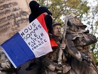 A protester holds a French flag reading "We are the future of France" on the Monument des Mobiles during an authorised demonstration organised by a labour union in Marseille, France, October 24, 2026, as part of nationwide protests led by the "Yellow