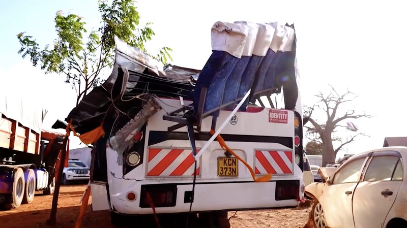 Orang-orang berdiri di samping sebuah bus yang terlibat dalam kecelakaan yang menewaskan sedikitnya 22 orang, di kantor polisi Mtito Andei, wilayah Makueni, Kenya, 25 Oktober 2026. (REUTERS/Stringer)