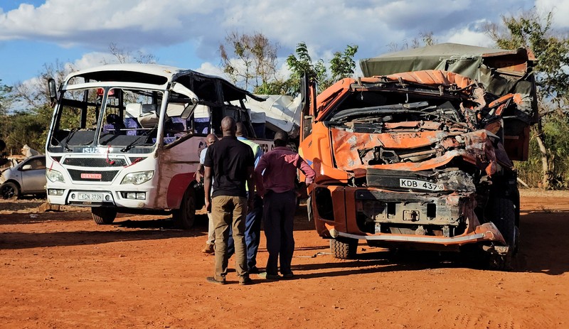 Orang-orang berdiri di samping sebuah bus yang terlibat dalam kecelakaan yang menewaskan sedikitnya 22 orang, di kantor polisi Mtito Andei, wilayah Makueni, Kenya, 25 Oktober 2026. (REUTERS/Stringer)