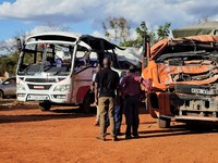Orang-orang berdiri di samping sebuah bus yang terlibat dalam kecelakaan yang menewaskan sedikitnya 22 orang, di kantor polisi Mtito Andei, wilayah Makueni, Kenya, 25 Oktober 2026. (REUTERS/Stringer)