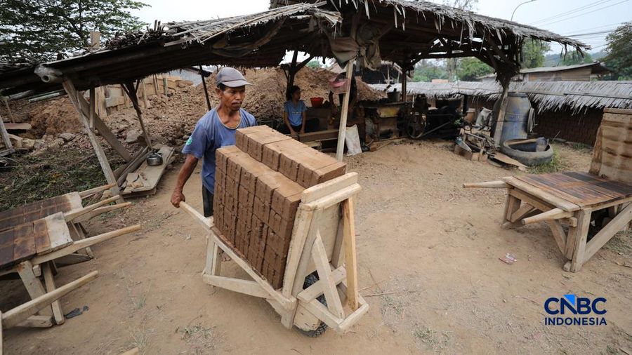 Pekerja mengangkut bata merah yang baru dicetak untuk dijemur di Kampung Setu, Kecamatan Waringinkurung, Serang, Banten, Minggu (25/10/2026). Usaha pembuatan bata merah yang dijual seharga Rp260/buah kini menjadi kegiatan ekoniomi produktif bagi seba