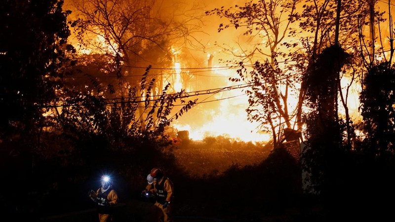Petugas pemadam kebakaran berjalan di depan lokasi kebakaran yang terjadi di Desa Guryong, Seoul, Korea Selatan, pada 27 Oktober 2026.