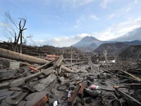 Foto yang diambil di Desa Kinahrejo ini memperlihatkan kehancuran pascaerupsi Gunung Merapi (di latar belakang), tepat di dekat rumah sosok yang dianggap sebagai "juru kunci" gunung tersebut, Mbah Marijan, di Sleman pada 28 Oktober 2010. (Photo by AD