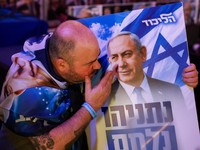 A supporter reacts to exit polls with a sign depicting Israeli Prime Minister and Likud party leader Benjamin Netanyahu during Israel's national election, at Likud's election headquarters in Jerusalem, October 27, 2026. REUTERS/Ronen Zvulun     TPX I