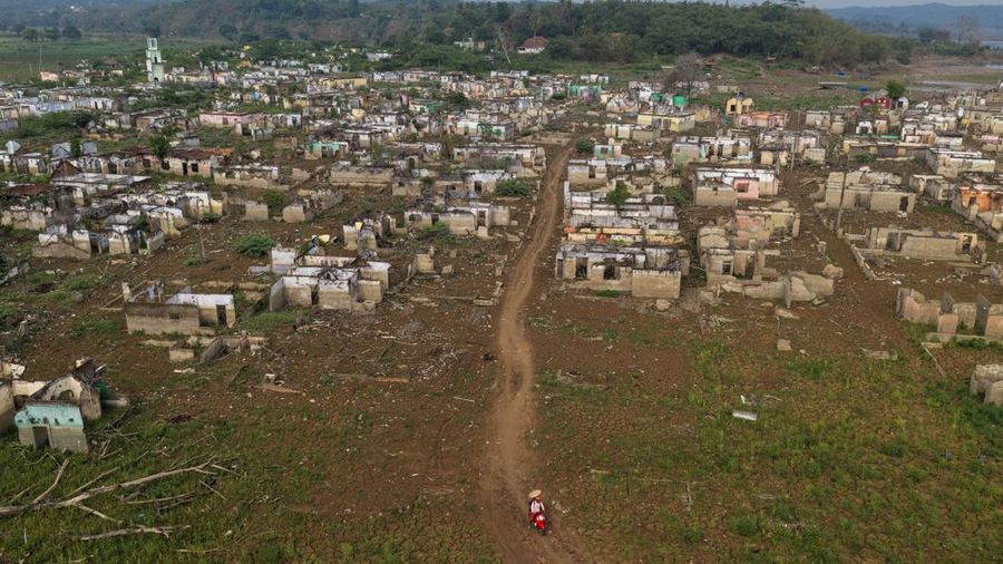 Tampilan dari drone memperlihatkan seorang pengendara melintas di dekat sisa-sisa Desa Somang yang muncul kembali setelah permukaan air di waduk Karian—sumber pasokan air untuk wilayah sekitarnya, termasuk Jakarta—menurun akibat kekeringan berkepanjangan yang dipicu oleh fenomena El Nino, di Lebak, Provinsi Banten, Indonesia, 23 Oktober 2026.