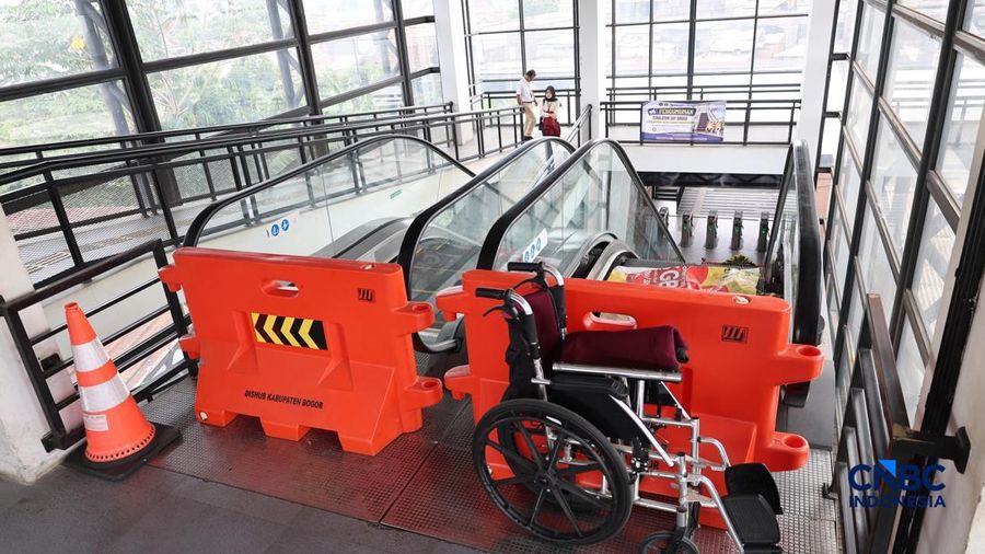 Sejumlah calon penumpang melintas di samping Karangan bunga di depan eskalator mati di Stasiun Bojonggede, Kab Bogor, Jawa Barat, Kamis, (29/10/2026). (CNBC Indonesia/Muhammad Sabki)
