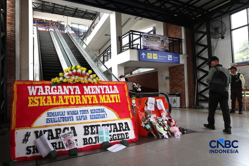 Sejumlah calon penumpang melintas di samping Karangan bunga di depan eskalator mati di Stasiun Bojonggede, Kab Bogor, Jawa Barat, Kamis, (29/10/2026). (CNBC Indonesia/Muhammad Sabki)