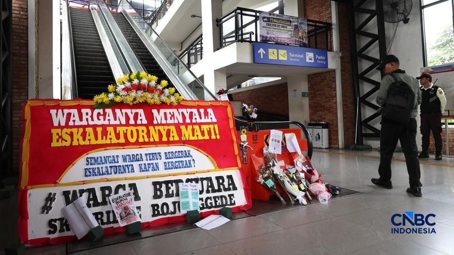 Sejumlah calon penumpang melintas di samping Karangan bunga di depan eskalator mati di Stasiun Bojonggede, Kab Bogor, Jawa Barat, Kamis, (29/10/2026). (CNBC Indonesia/Muhammad Sabki)