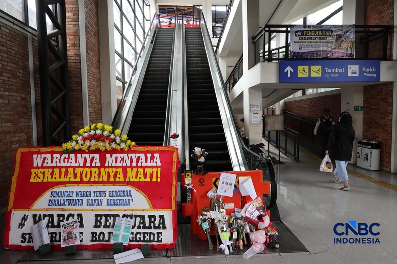 Sejumlah calon penumpang melintas di samping Karangan bunga di depan eskalator mati di Stasiun Bojonggede, Kab Bogor, Jawa Barat, Kamis, (29/10/2026). (CNBC Indonesia/Muhammad Sabki)
