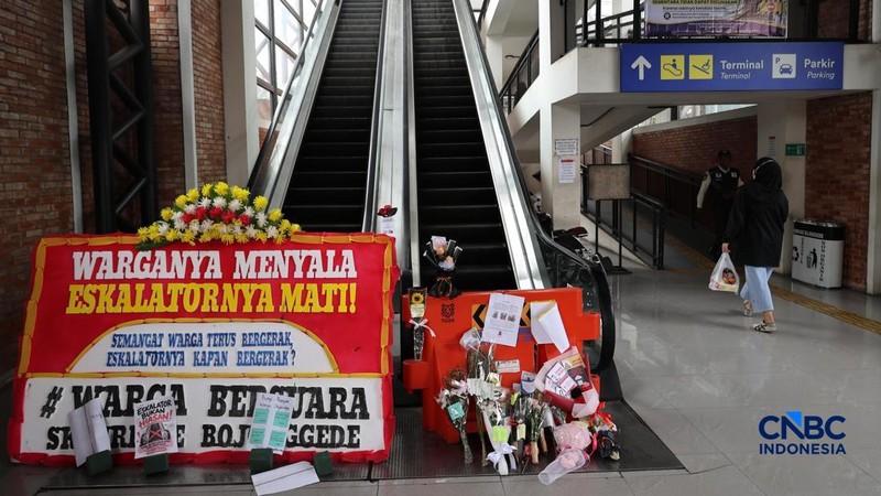 Sejumlah calon penumpang melintas di samping Karangan bunga di depan eskalator mati di Stasiun Bojonggede, Kab Bogor, Jawa Barat, Kamis, (29/10/2026). (CNBC Indonesia/Muhammad Sabki)