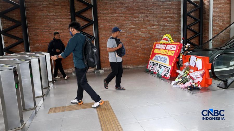 Sejumlah calon penumpang melintas di samping Karangan bunga di depan eskalator mati di Stasiun Bojonggede, Kab Bogor, Jawa Barat, Kamis, (29/10/2026). (CNBC Indonesia/Muhammad Sabki)