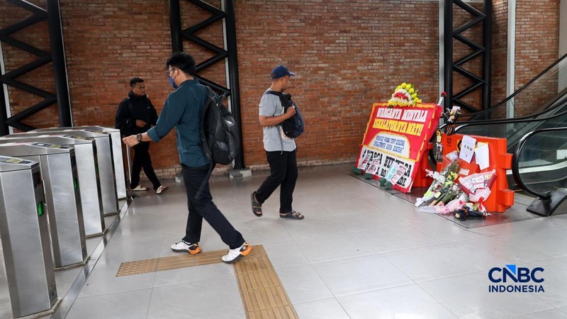 Sejumlah calon penumpang melintas di samping Karangan bunga di depan eskalator mati di Stasiun Bojonggede, Kab Bogor, Jawa Barat, Kamis, (29/10/2026). (CNBC Indonesia/Muhammad Sabki)