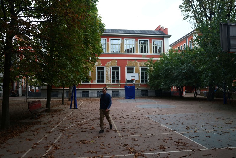Seorang siswi mengangkat tangannya sementara Giovanni Pavese, guru musik, memperhatikan selama pelajaran di sebuah ruang kelas di sekolah komprehensif negeri 'Simona Giorgi', di Milan, Italia, 23 Oktober 2026. (REUTERS/Claudia Greco)