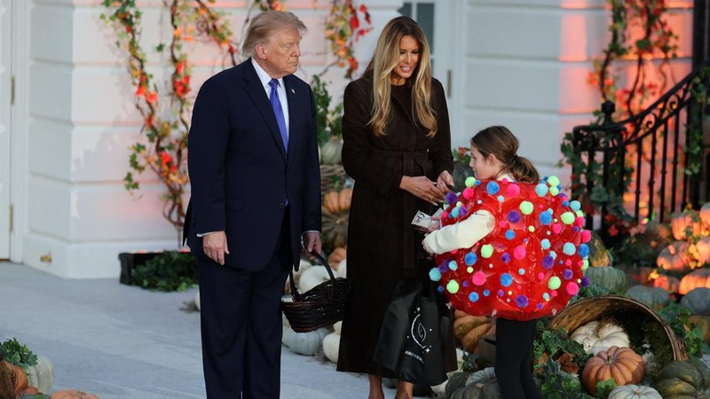 Presiden AS Donald Trump dan Ibu Negara Melania Trump membagikan permen kepada seorang anak dalam acara Halloween di Gedung Putih di Washington, DC, AS, pada 29 Oktober 2026.