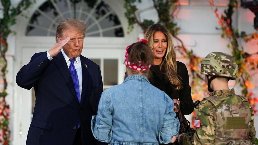 Presiden AS Donald Trump memberikan hormat kepada seorang anak yang berpakaian seperti tentara di samping Ibu Negara Melania Trump, saat mereka mengadakan acara Halloween di Gedung Putih di Washington, DC, AS, pada 29 Oktober 2026. (REUTERS/Eric Lee)