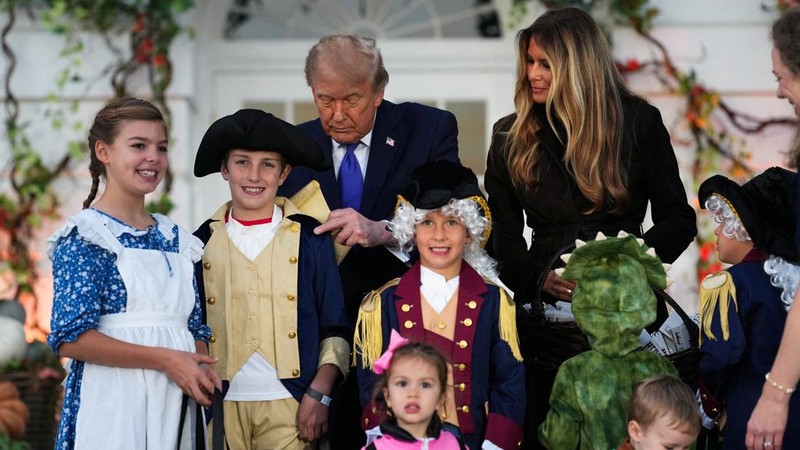 Presiden AS Donald Trump menandatangani sebuah dokumen di samping Ibu Negara Melania Trump saat mereka menjadi tuan rumah acara Halloween di Gedung Putih di Washington, DC, AS, pada 29 Oktober 2026.