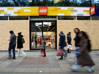 Orang-orang berjalan melewati sebuah toko Lego yang diamankan dengan papan kayu menjelang aksi protes yang diperkirakan akan dilakukan oleh gerakan pemuda "Gen Z regelt" di Berlin, Jerman, pada 30 Oktober 2026. (REUTERS/Annegret Hilse)