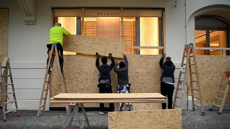 Para pekerja memasang papan kayu untuk mengamankan toko Bvlgari menjelang aksi protes yang diperkirakan akan dilakukan oleh gerakan pemuda "Gen Z regelt" di Berlin, Jerman, pada 30 Oktober 2026. (REUTERS/Annegret Hilse)